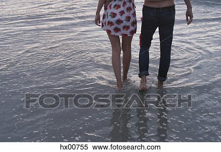 Stock Photography - Young couple walking in ocean surf. Fotosearch
