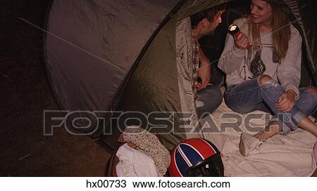 Young couple with flashlight inside camping tent View Large Photo Image Stock Image - Young couple with flashlight inside camping tent. Fotosearch
