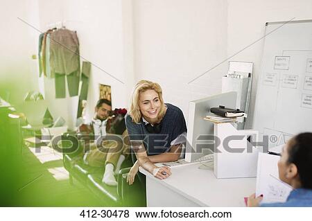 Stock Photo - Young creative business people brainstorming in office. Fotosearch
