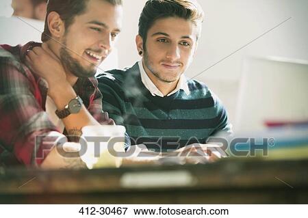 Young creative businessmen working at laptop in office View Large Photo Image Stock Photo - Young creative businessmen working at laptop in office. Fotosearch