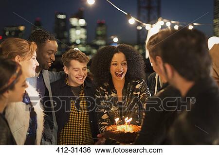 Young friends celebrating birthday at rooftop party View Large Photo Image Stock Photograph - Young friends celebrating birthday at rooftop party. Fotosearch