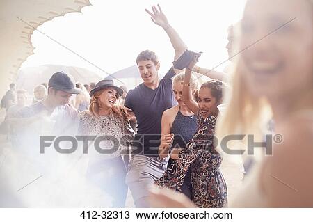 Young friends dancing at music festival View Large Photo Image Stock Image - Young friends dancing at music festival. Fotosearch