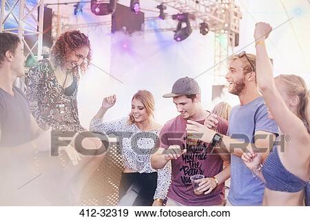 Young friends dancing at music festival View Large Photo Image Stock Photo - Young friends dancing at music festival. Fotosearch