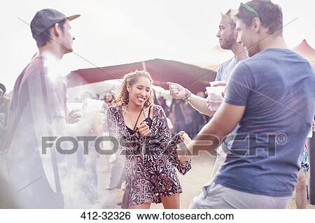Young friends dancing at music festival View Large Photo Image Stock Photograph - Young friends dancing at music festival. Fotosearch