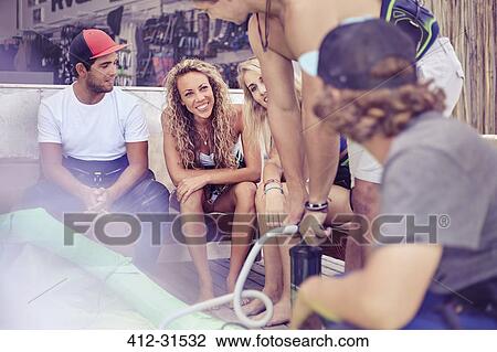 Young friends hanging out at surf shop View Large Photo Image Stock Image - Young friends hanging out at surf shop. Fotosearch