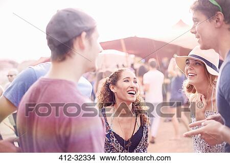 Young friends hanging out talking at music festival View Large Photo Image Picture - Young friends hanging out talking at music festival. Fotosearch
