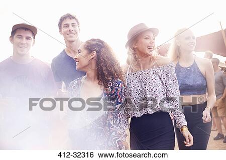 Young friends walking at music festival View Large Photo Image Stock Photograph - Young friends walking at music festival. Fotosearch