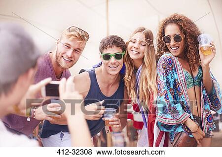 Young friends with beer posing for camera phone at music festival View Large Photo Image Stock Photo - Young friends with beer posing for camera phone at music festival. Fotosearch
