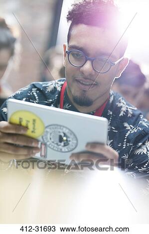Young man using digital tablet at technology conference View Large Photo Image Stock Image - Young man using digital tablet at technology conference. Fotosearch