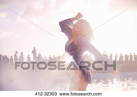 Young woman dancing at sunny poolside party View Large Photo Image Stock Image - Young woman dancing at sunny poolside party. Fotosearch