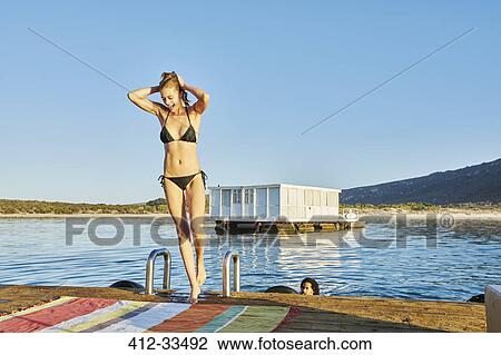Young woman in bathing suit on sunny summer dock View Large Photo Image Stock Image - Young woman in bathing suit on sunny summer dock. Fotosearch
