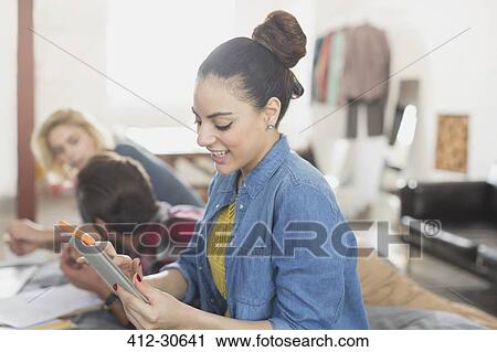 Young woman using digital tablet View Large Photo Image Stock Image - Young woman using digital tablet. Fotosearch