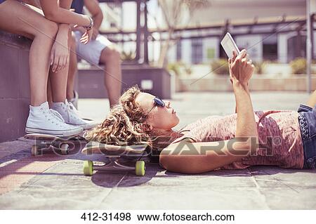 Young woman with digital tablet laying on skateboard View Large Photo Image Stock Photo - Young woman with digital tablet laying on skateboard. Fotosearch