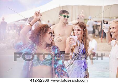 Young women dancing at music festival View Large Photo Image Stock Photograph - Young women dancing at music festival. Fotosearch
