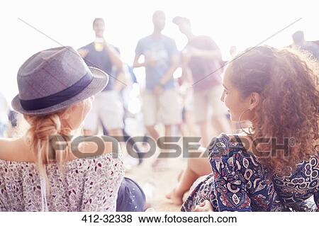 Stock Photo - Young women relaxing hanging out at music festival. Fotosearch