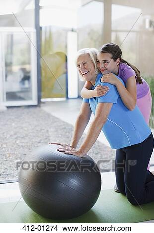 Girl hugging grandmother on exercise ball View Large Photo Image Picture - Girl hugging grandmother on exercise ball. Fotosearch