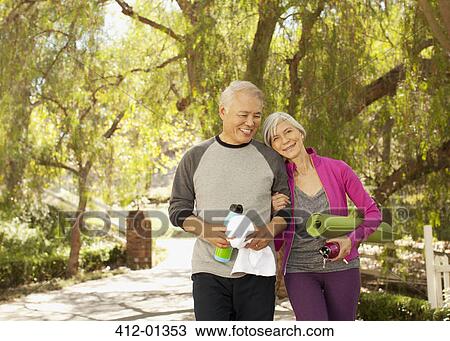 Older couple walking together outdoors View Large Photo Image Stock Image - Older couple walking together outdoors. Fotosearch