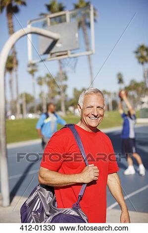 Older man carrying gym bag on court View Large Photo Image Stock Image - Older man carrying gym bag on court. Fotosearch