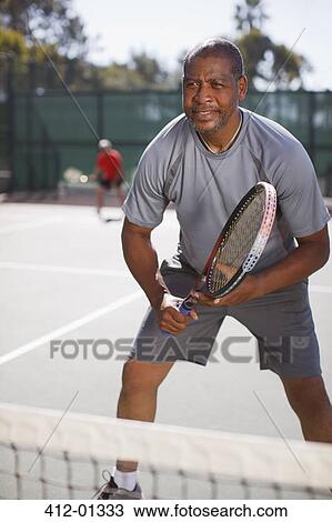 Older man playing tennis on court View Large Photo Image Stock Image - Older man playing tennis on court. Fotosearch