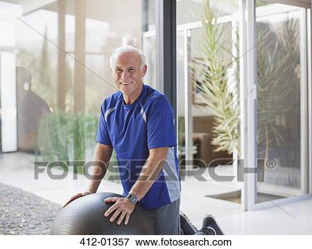 Older man using exercise ball in home View Large Photo Image Stock Photo - Older man using exercise ball in home. Fotosearch
