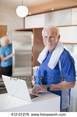Stock Photo - Older man using laptop after workout. Fotosearch