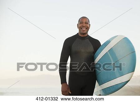 Older surfer carrying board on beach View Large Photo Image Stock Image - Older surfer carrying board on beach. Fotosearch