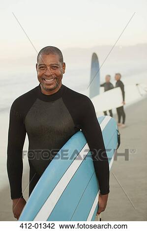 Older surfer carrying board on beach View Large Photo Image Stock Image - Older surfer carrying board on beach. Fotosearch