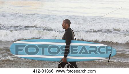 Older surfer carrying board on beach View Large Photo Image Stock Photograph - Older surfer carrying board on beach. Fotosearch