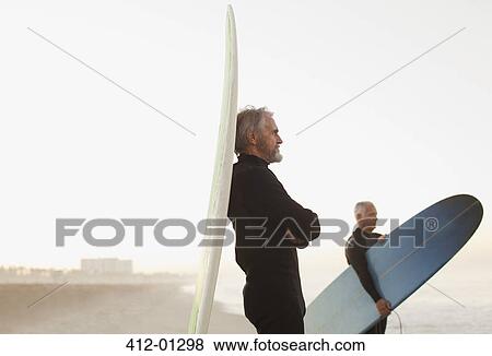 Older surfer leaning on board on beach View Large Photo Image Stock Photo - Older surfer leaning on board on beach. Fotosearch