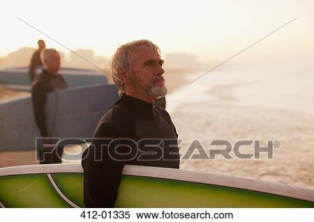 Older surfers carrying boards on beach View Large Photo Image Stock Photography - Older surfers carrying boards on beach. Fotosearch