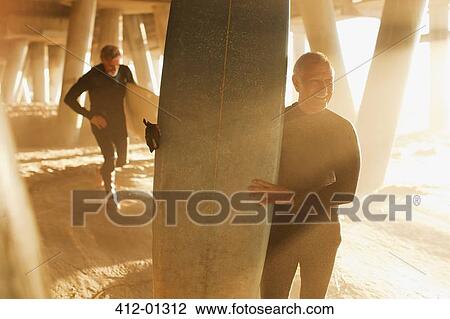 Older surfers carrying boards under pier View Large Photo Image Stock Image - Older surfers carrying boards under pier. Fotosearch