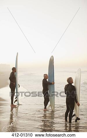 Older surfers holding boards on beach View Large Photo Image Stock Image - Older surfers holding boards on beach. Fotosearch