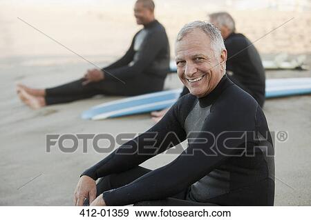 Older surfers sitting on boards on beach View Large Photo Image Stock Photo - Older surfers sitting on boards on beach. Fotosearch