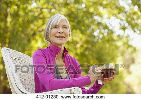Older woman drinking tea outdoors View Large Photo Image Stock Image - Older woman drinking tea outdoors. Fotosearch