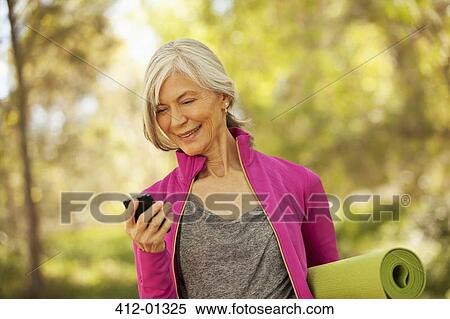 Older woman using cell phone outdoors View Large Photo Image Stock Photography - Older woman using cell phone outdoors. Fotosearch