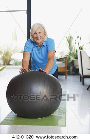 Older woman using exercise ball in home View Large Photo Image Stock Image - Older woman using exercise ball in home. Fotosearch