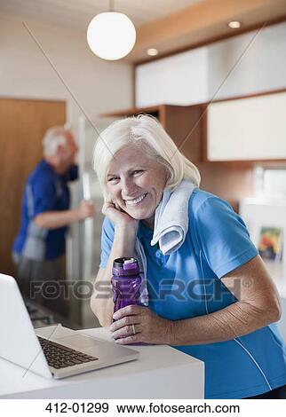 Stock Photo - Older woman using laptop after workout. Fotosearch