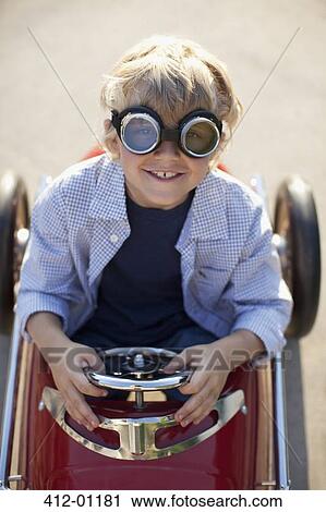 Stock Image - Boy wearing goggles in go cart. Fotosearch