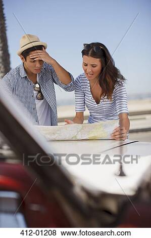 Stock Photo - Frustrated couple reading road map. Fotosearch