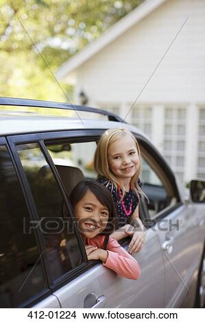 Picture - Girls smiling out car window. Fotosearch
