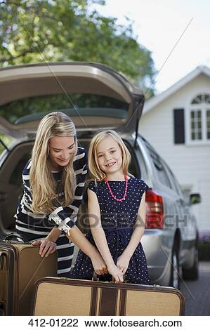 Mother and daughter carrying luggage to car View Large Photo Image Stock Image - Mother and daughter carrying luggage to car. Fotosearch