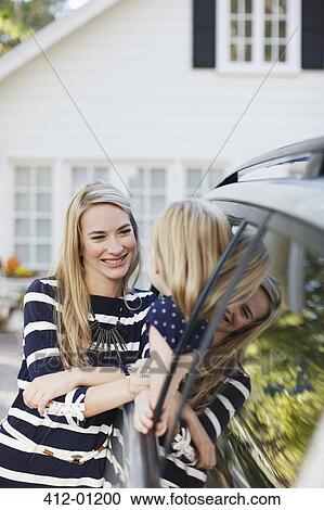Stock Image - Mother talking to daughter in car window. Fotosearch