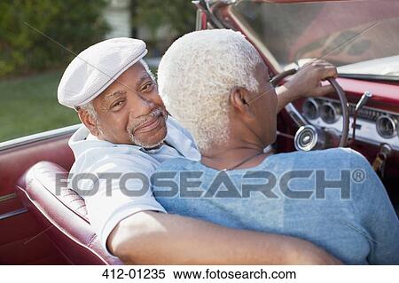 Stock Photography - Older couple sitting in convertible. Fotosearch