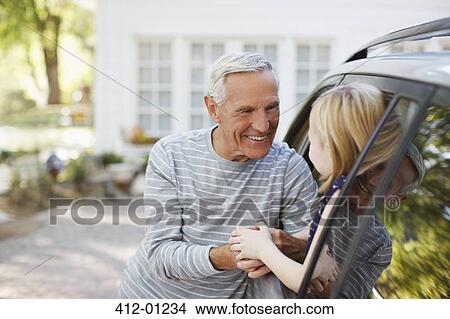 Older man greeting granddaughter in car window View Large Photo Image Picture - Older man greeting granddaughter in car window. Fotosearch