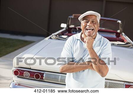 Stock Photography - Older man smiling with convertible. Fotosearch