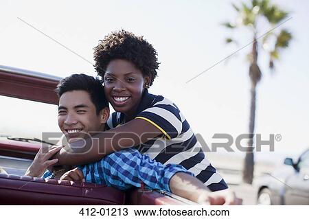 Smiling couple hugging in convertible View Large Photo Image Stock Image - Smiling couple hugging in convertible. Fotosearch