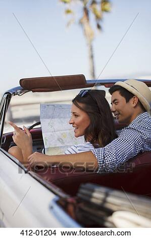 Smiling couple reading road map convertible View Large Photo Image Picture - Smiling couple reading road map convertible. Fotosearch