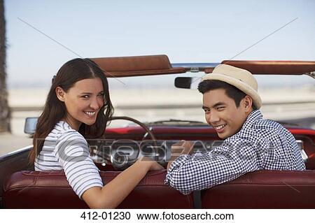 Smiling couple sitting in convertible View Large Photo Image Stock Image - Smiling couple sitting in convertible. Fotosearch