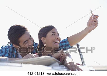 Stock Photo - Smiling couple taking picture of themselves. Fotosearch