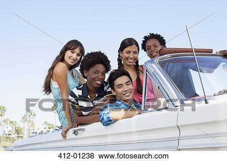 Smiling friends sitting in convertible View Large Photo Image Stock Photo - Smiling friends sitting in convertible. Fotosearch